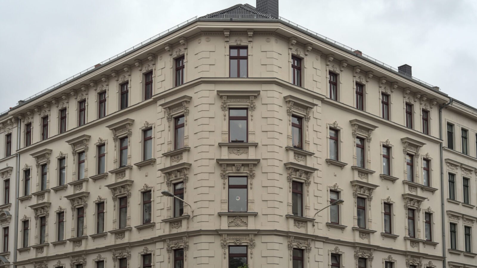 Fassade eines Mehrfamilienhauses in einer deutschen Stadt mit zahlreichen Fenstern und Balkonen
