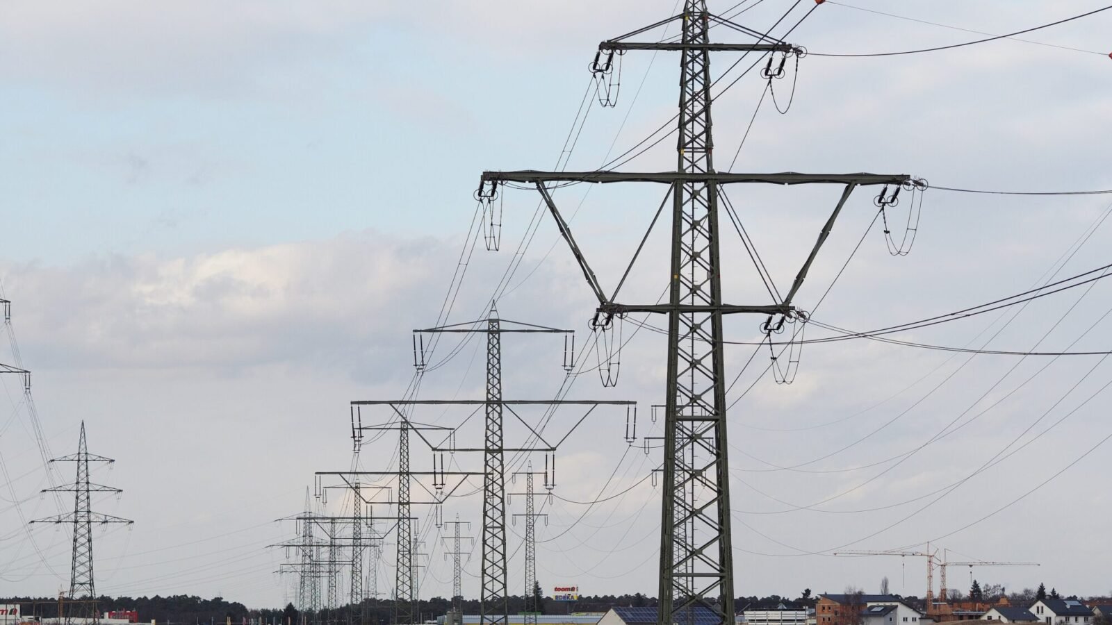 Hochspannungsmasten einer Stromleitung bei Pfungstadt unter bewölktem Himmel