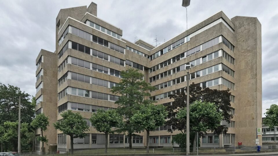 Bürogebäude der Agentur für Arbeit in Wiesbaden mit Bäumen und Straße davor