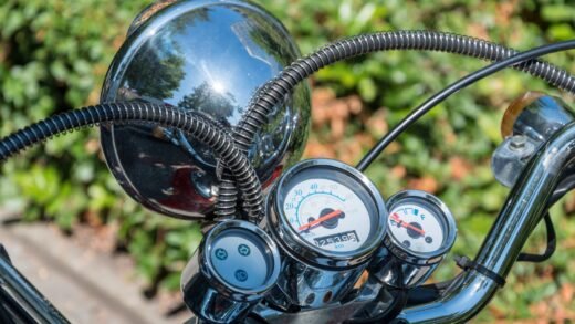 Scheinwerfer und Tachometer eines Motorrollers in Nahaufnahme vor grünem Hintergrund